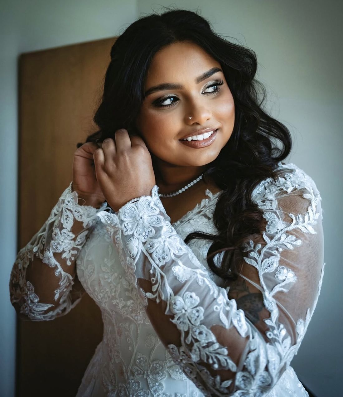 Bride in long lace sleeves with a shimmering eye and glossy lip