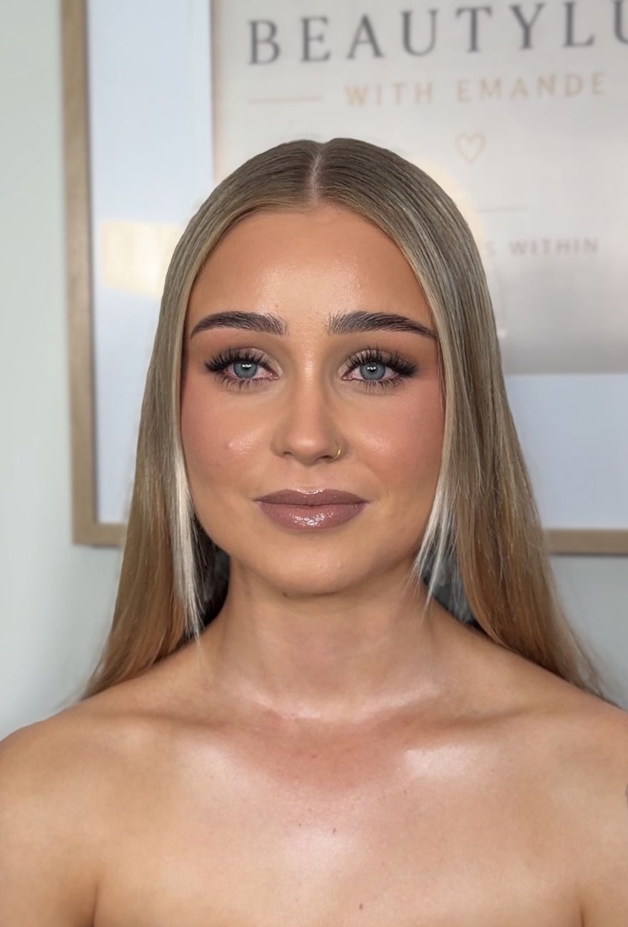 Bronzed glam with full lashes and a glossy mauve lip